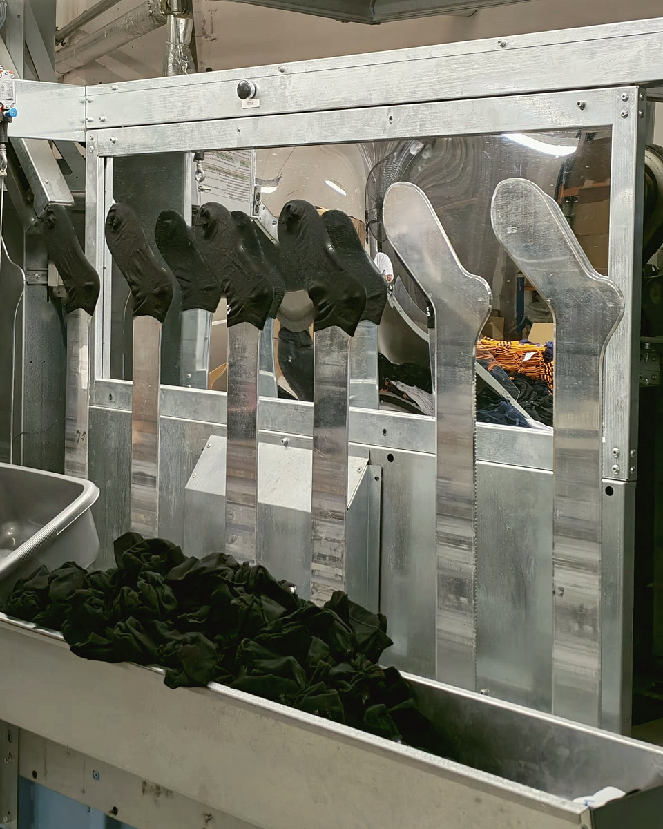Tecnopea otomatik buharlı ütünün metal kalıplarına geçirilmiş siyah çoraplar